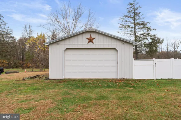 a white house that has tree in front of it