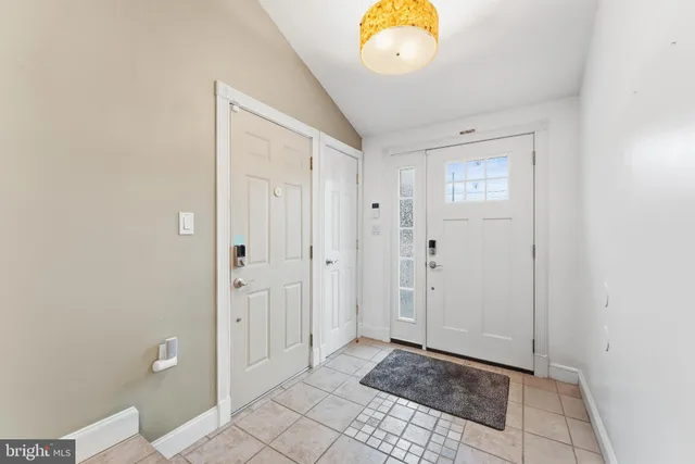 a view of a hallway with wooden floor and a bathroom
