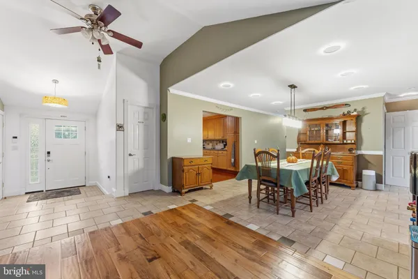 a living room with furniture a dining table and chairs with wooden floor