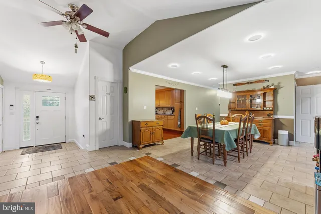 a living room with furniture a dining table and chairs with wooden floor