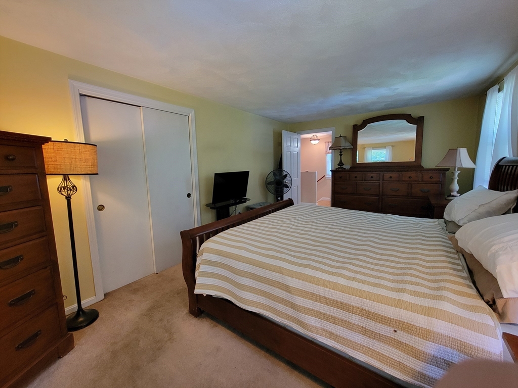 75 Brown Street Tewksbury, MA 01876 - Photo 18 of 28 a bedroom with a bed and a mirror on dresser