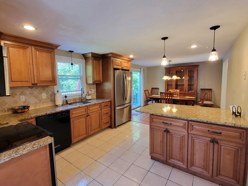 75 Brown Street Tewksbury, MA 01876 - Photo 2 of 28 a kitchen with kitchen island granite countertop a sink counter top space appliances and cabinets