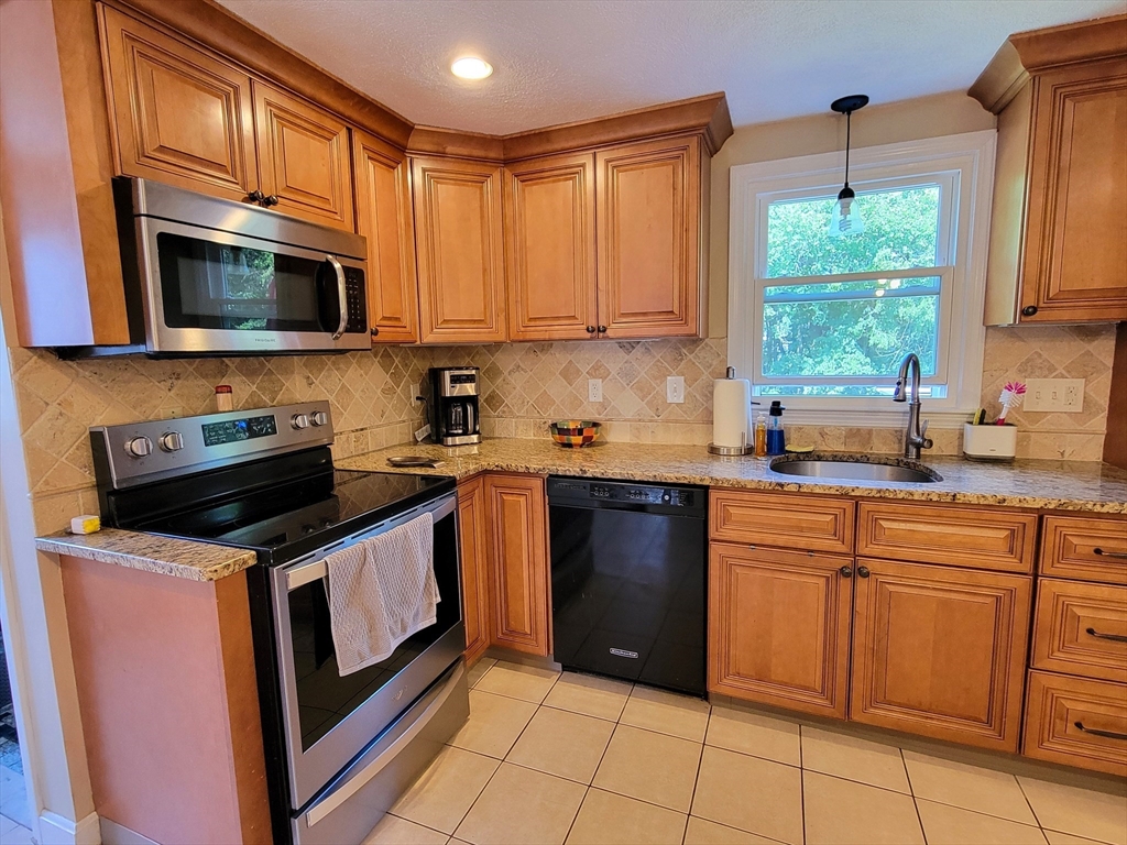 75 Brown Street Tewksbury, MA 01876 - Photo 3 of 28 a kitchen with a stove a sink and a microwave