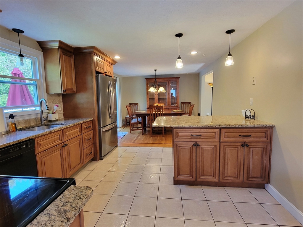 75 Brown Street Tewksbury, MA 01876 - Photo 4 of 28 a kitchen with stainless steel appliances granite countertop a sink and cabinets