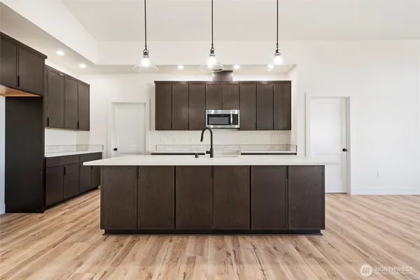 a kitchen with stainless steel appliances kitchen island granite countertop a sink and a stove
