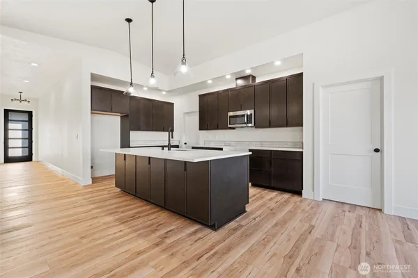 a large kitchen with kitchen island a sink stainless steel appliances and cabinets