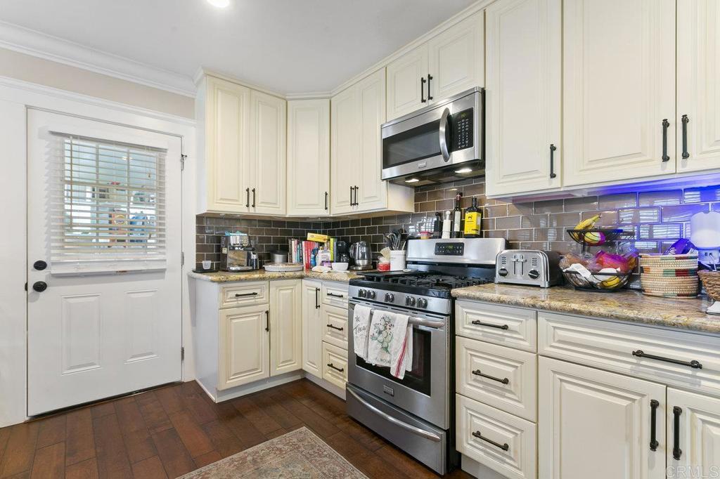 3373-3379 1/2 Herman Avenue San Diego, CA 92104 - Photo 14 of 70 a kitchen with stainless steel appliances granite countertop a stove a sink and white cabinets