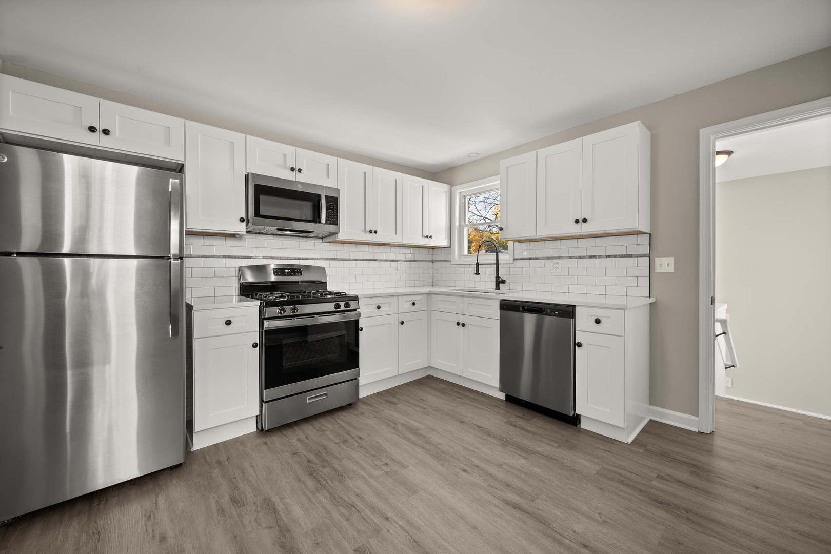 321 North Locust Street Sycamore, IL 60178 - Photo 9 of 38 a kitchen with a refrigerator stove and white cabinets