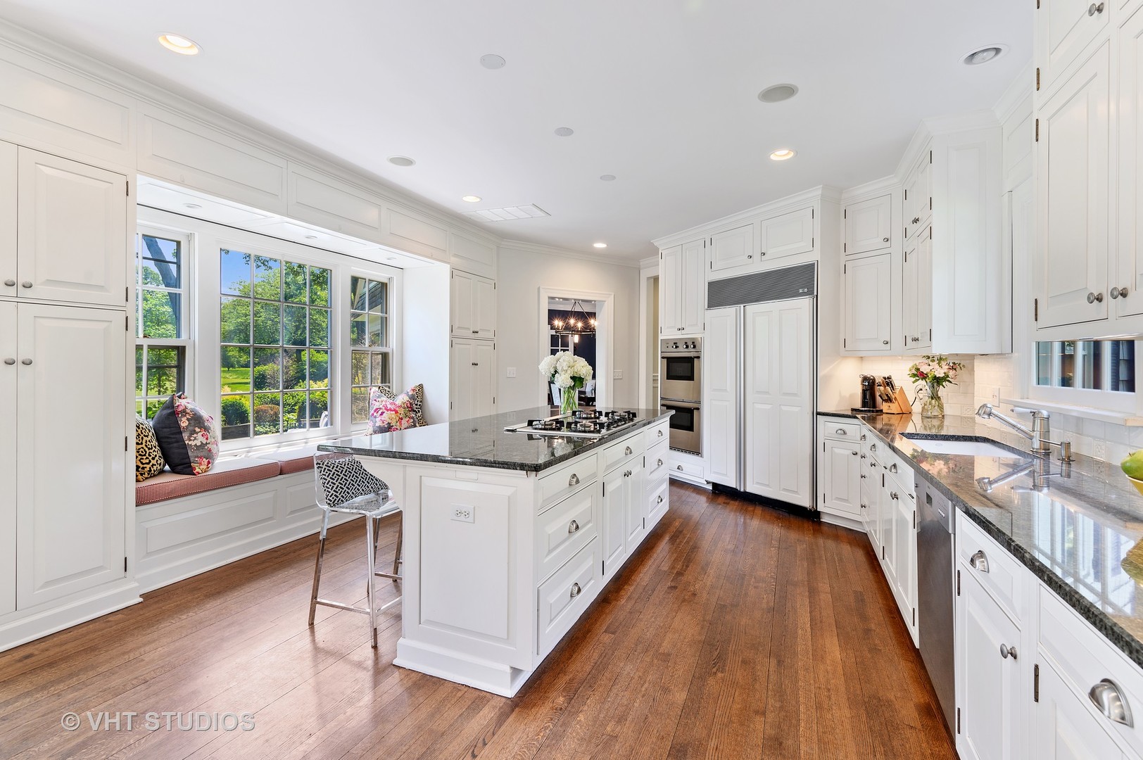 44 Indian Hill Road Winnetka, IL 60093 - Photo 25 of 49 a large white kitchen with wooden floors and stainless steel appliances