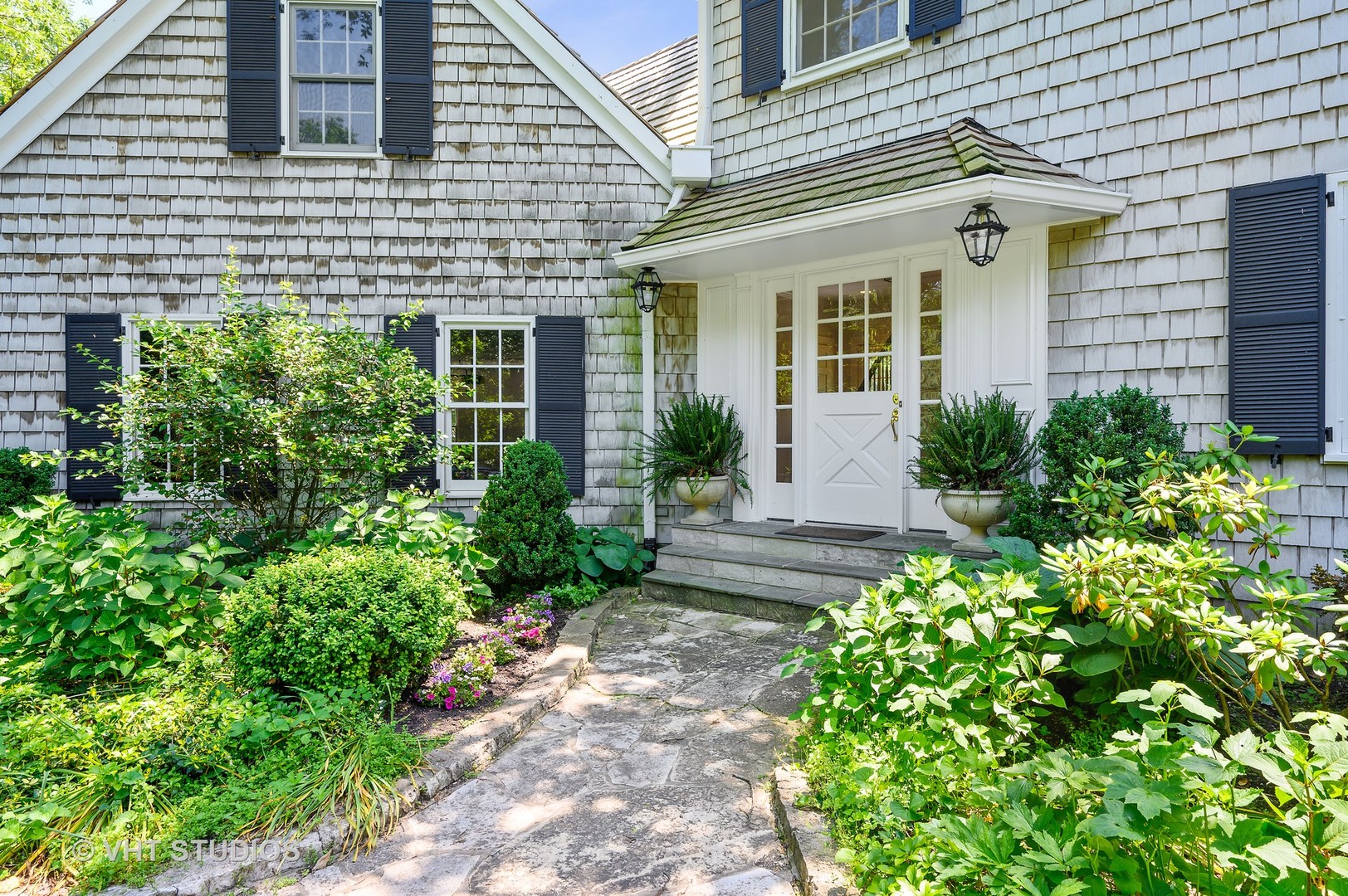 44 Indian Hill Road Winnetka, IL 60093 - Photo 46 of 49 a view of a house with potted plants and a flower garden