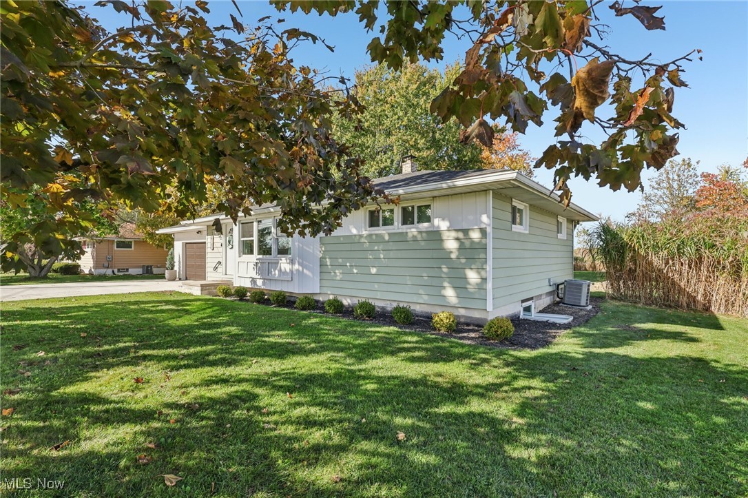 6147 Stone Road Medina, OH 44256 - Photo 34 of 40 View of front facade with a front yard, concrete driveway, a chimney, and a garage