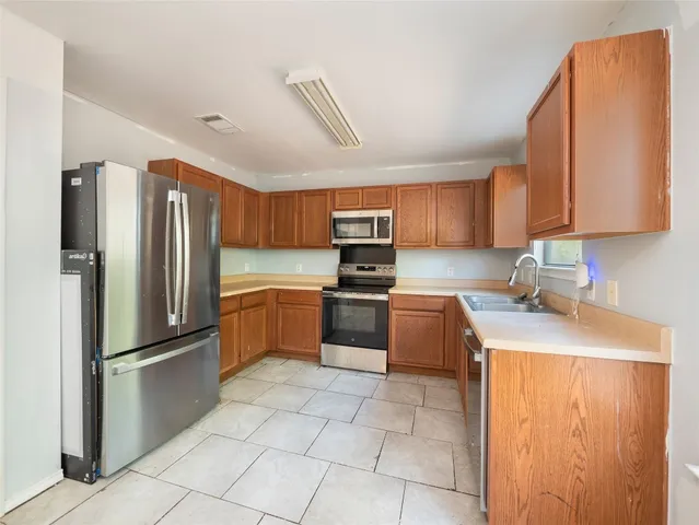 a kitchen with stainless steel appliances granite countertop a refrigerator sink and stove