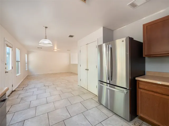 a kitchen with stainless steel appliances a refrigerator and a stove top oven