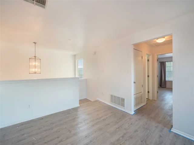 an empty room with wooden floor and window