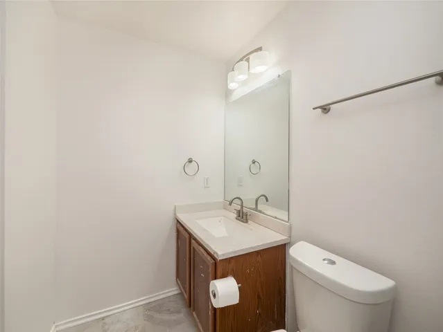 a bathroom with a toilet a sink and mirror