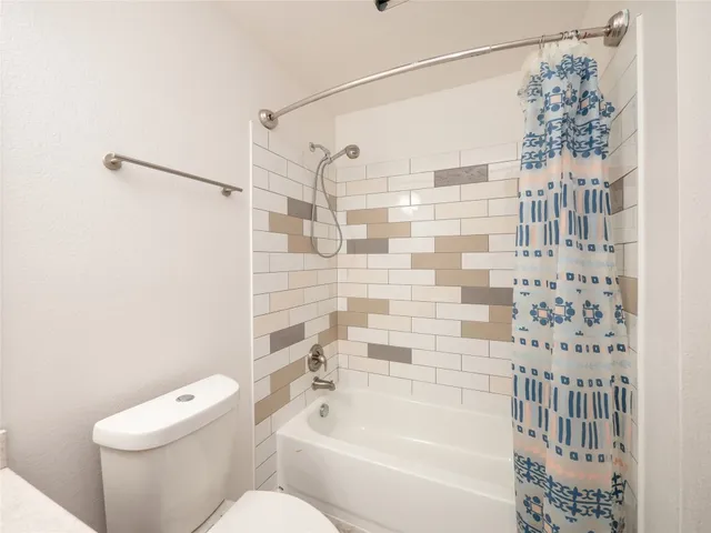 a bathroom with a toilet and shower