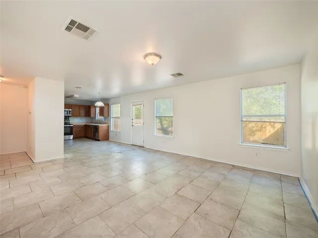 an empty room with a fireplace and windows