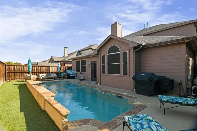 a view of a house with swimming pool and sitting area