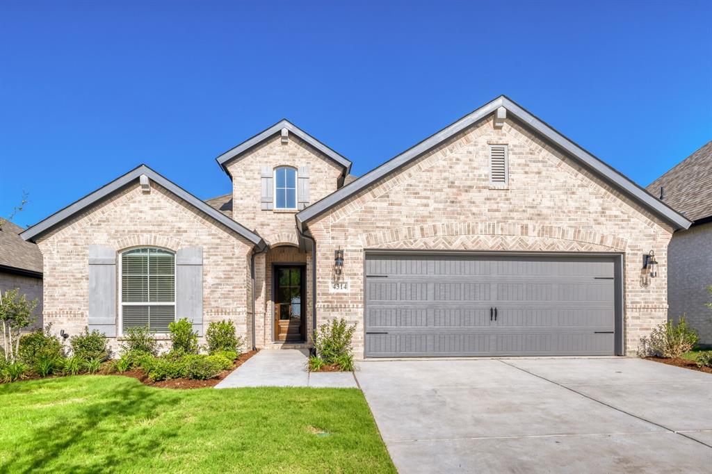 4314 Haley Way Oak Point, TX 75068 - Photo 1 of 28 Light-colored brick facade with grey roofing and a two-car garage