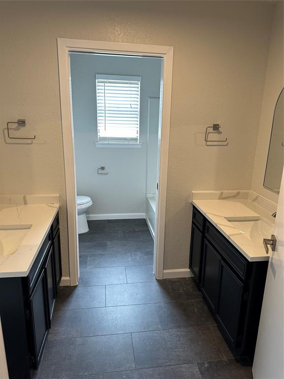 4520 Speedway, Unit A Austin, TX 78751 - Photo 5 of 9 Full bathroom featuring two vanities and a textured wall