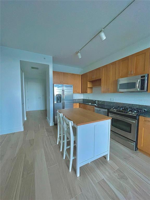 150 East Robinson Street, Unit 2A6 Orlando, FL 32801 - Photo 13 of 33 a kitchen with wooden floors and wooden cabinets