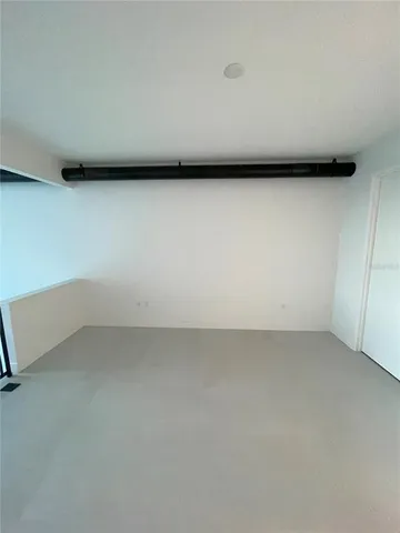 a room with stainless steel appliances wooden floors sink and window