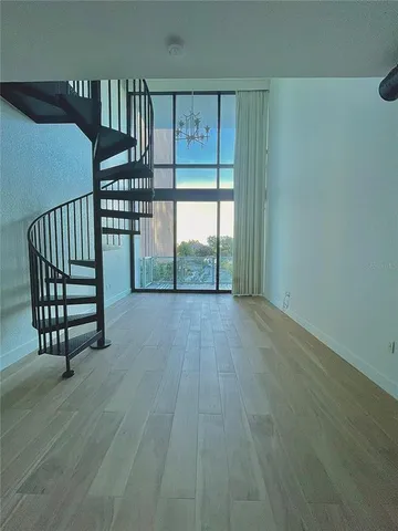 a view of a room with wooden floor and furniture