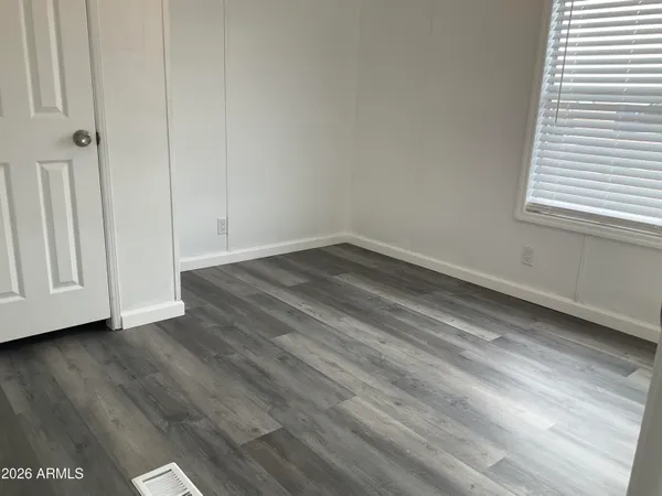 a view of a small space with wooden floor and a window