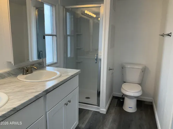 a bathroom with a granite countertop sink toilet and a mirror