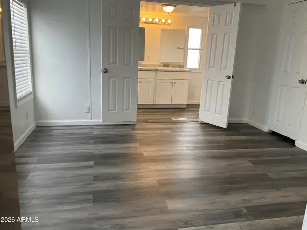 a view of a hallway with wooden floor and a cabinet