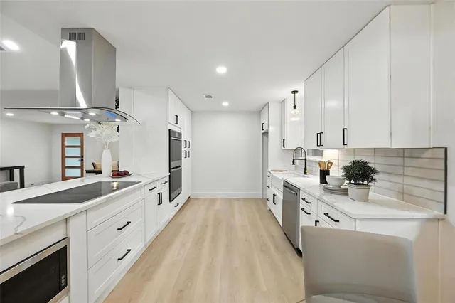 a kitchen with stainless steel appliances granite countertop a sink and a refrigerator