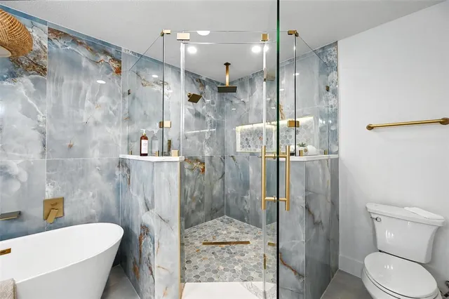 a bathroom with a sink toilet vanity and shower