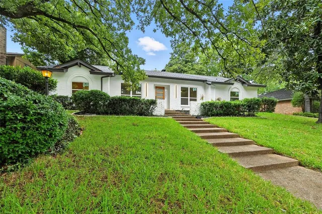 a front view of house with yard and green space