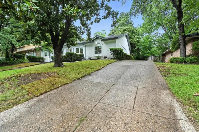 a front view of a house with a yard and trees
