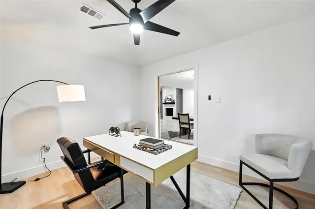 a living room with furniture kitchen view and a wooden floor