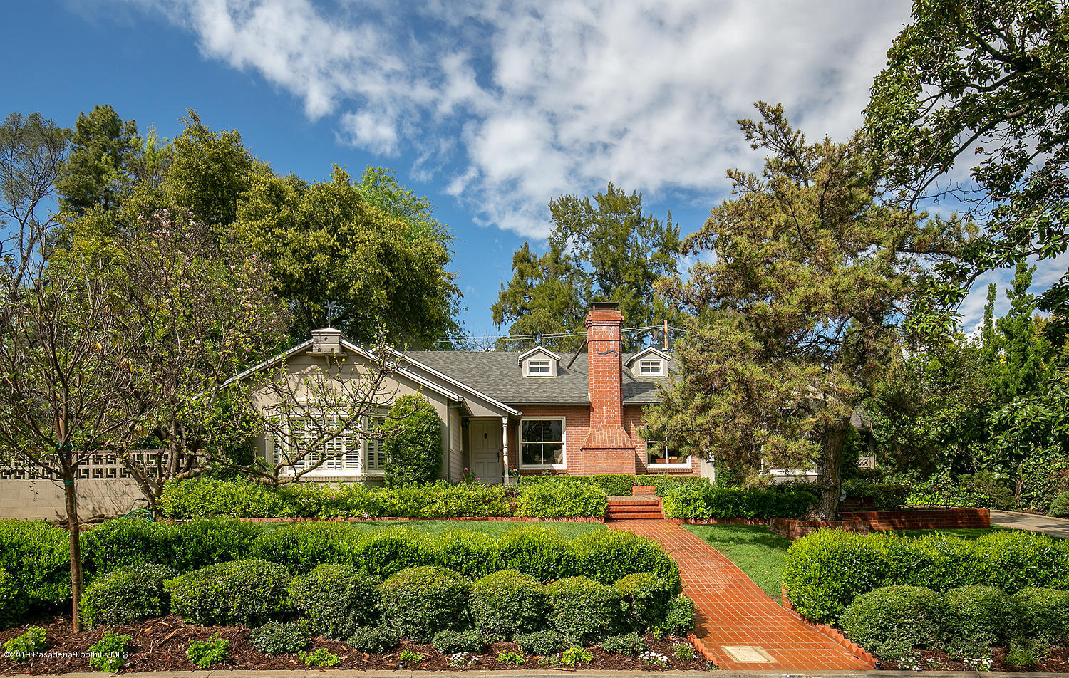 a front view of a house with a garden