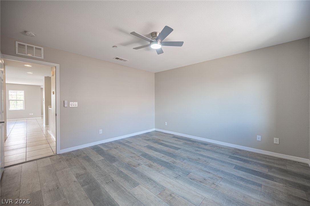 9916 Sable Point Street Las Vegas, NV 89178 - Photo 45 of 73 An airy bedroom with resilient wood-look flooring and a modern ceiling fan for comfort.