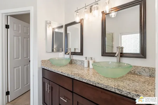 a bathroom with a granite countertop sink and a mirror