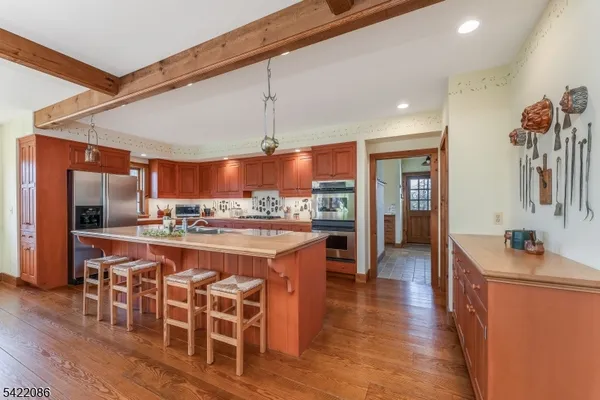 a dining room with wooden floor a chandelier a glass table and chairs
