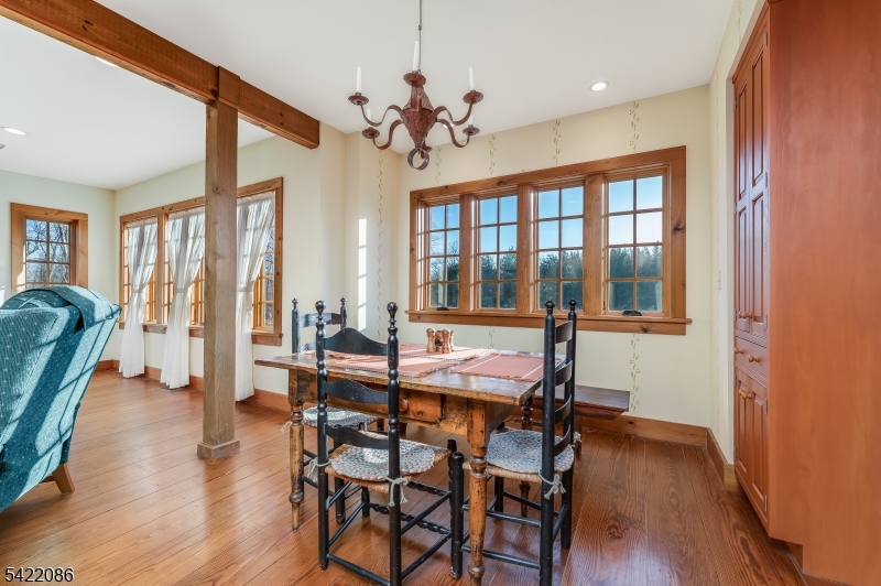348 Rosemont Ringoes Road Stockton, NJ 08559 - Photo 9 of 49 a dining room with wooden floor a chandelier a glass table and chairs