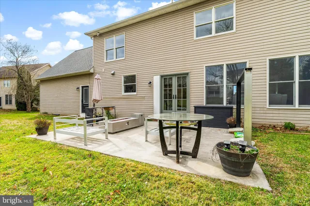 a view of a patio with dining table and chairs and potted plants