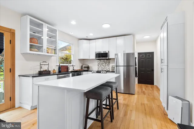 a kitchen with stainless steel appliances a refrigerator and a stove top oven