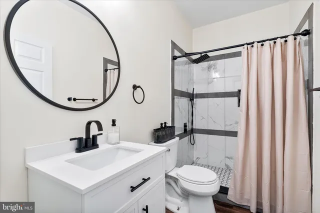 a bathroom with a sink toilet and a mirror