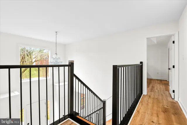 a view of a hallway with wooden floor and stairs