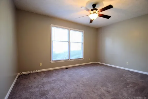 an empty room with a fan and a fan