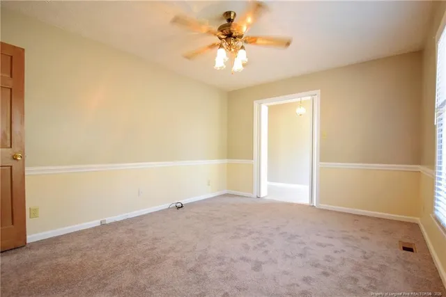a view of empty room with fireplace and window