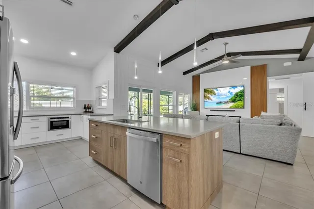 a living room with furniture kitchen view and a flat screen tv