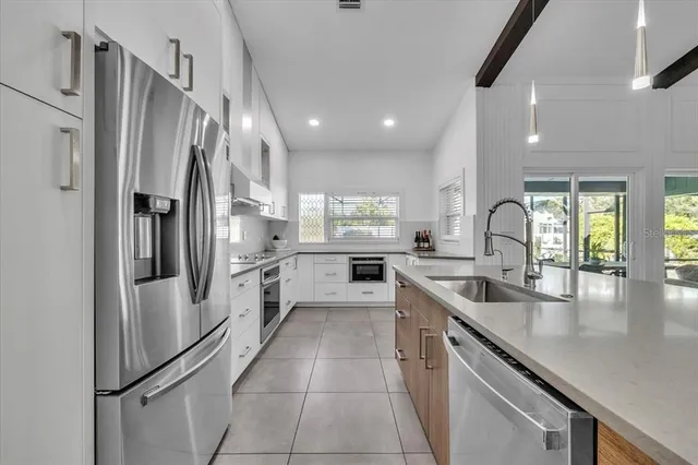 a living room with furniture kitchen view and a large window