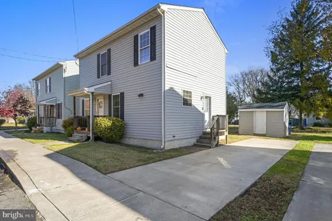 a view of a house with backyard and trees