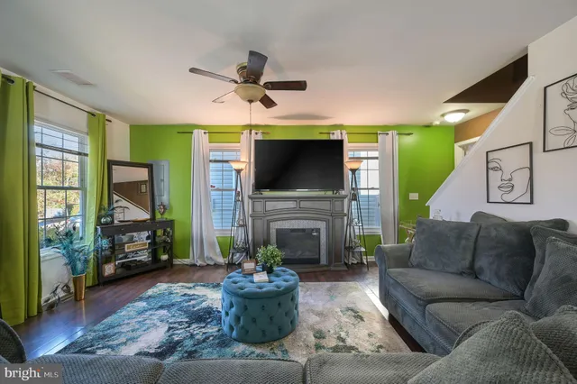 a living room with furniture a fireplace and a flat screen tv
